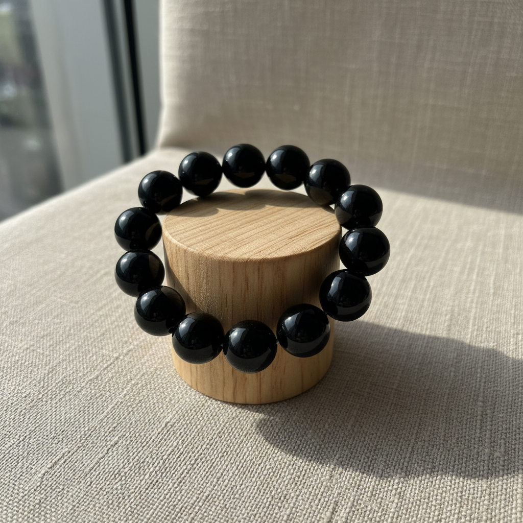 Black onyx bracelet on wood cylinder stand
