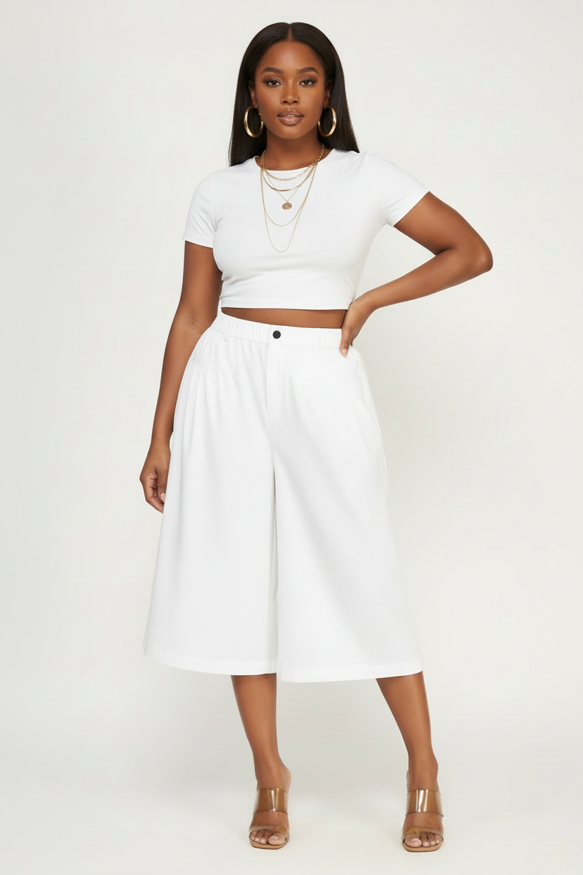 Cute curvy Black model wearing white pleated cropped wide leg culotte pants right at knee by House of FaSHUN