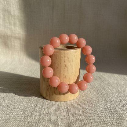 Peach coral bracelet on wood cylinder stand