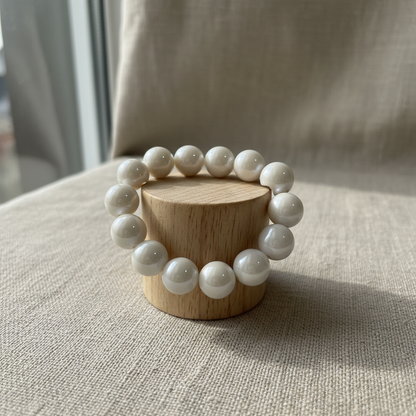 White pearlescent bracelet on wood cylinder stand